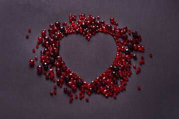 Red cut glass beads on black background, Heart shaped