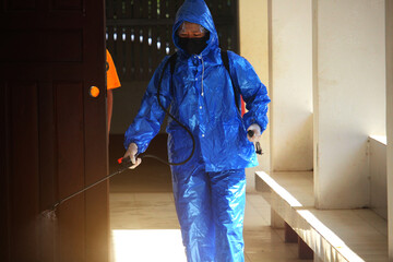 Health workers in sterile clothing are spraying chemicals to prevent the COVID-19 virus