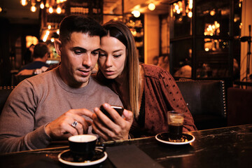 Young couple using mobile phone.