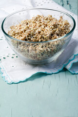 Bowl of sprouted green buckwheat isolated on white, top view
