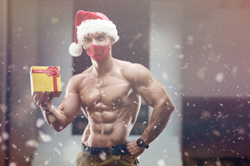Fitness man in Santa Claus hat costume in gym