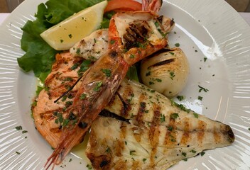 Fischplatte mit Languste Lachs gerillter Forelle Kammmuschel und Zitrone in einem Restaurant in Bardolino Gardasee Venetien Italien