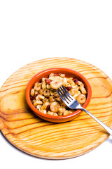 Prawns with garlic and cayenne in a ceramic bowl on a wooden tray