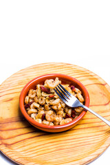 Prawns with garlic and cayenne in a ceramic bowl on a wooden tray