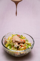 Prawn cocktail with lettuce, pink sauce, crab sticks, pineapple, apple. Glass bowl. A fresh, healthy, vegan and very healthy vegetarian appetizer and starter. No staining. Children's kitchen.