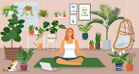 Obraz na płótnie Canvas Stay at home concept, young woman having yoga lessons over a video call at home decorated with indoor plants