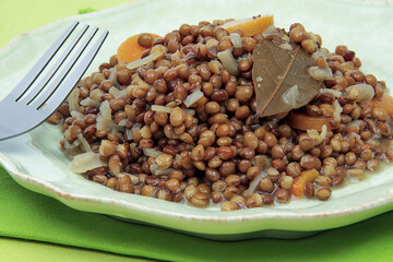 assiette de lentilles cuisinées avec oignons et carottes