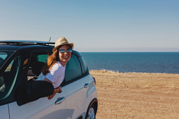 Happy woman in hat and sunglasses on summer roadtrip