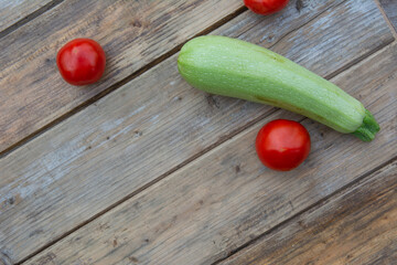 Tomatoes and zucchini on a wooden table background