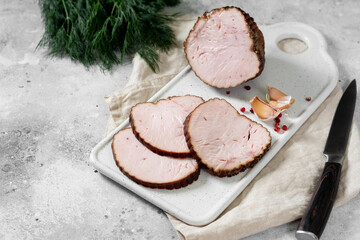 Meatloaf with herbs on a white ceramic serving Board on a light gray table. Baked meat	