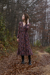 Outdoor portrait of woman in brown dress during foggy autumn morning in the countryside.