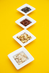 Tet Holiday, Lunar new year, chinese new year concept . Dried sunflower, lotus, watermelon and pumkin seeds top view isolated on yellow 