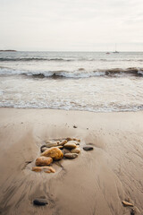 une plage de sable fin et des pierres. Une plage et la mer