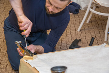 A man repairs furniture at home.