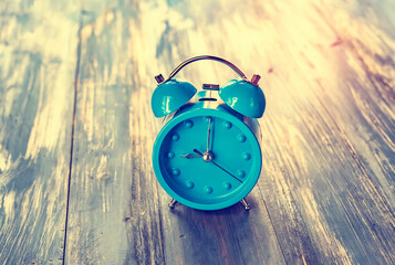 blue clock on antique rustic wood background.