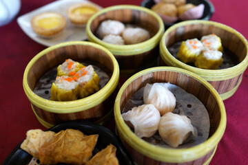 Variety of Dim Sum. Popular Dim Sum Dishes, Shumai, Har Gow and Egg Tart in Bamboo Steamer Tray.