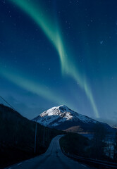 Aurora over a mountain and road in Norway