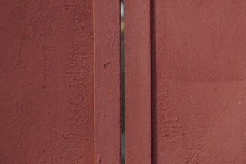 red metal texture from an old iron wall with a seam and crack in the gate on the street