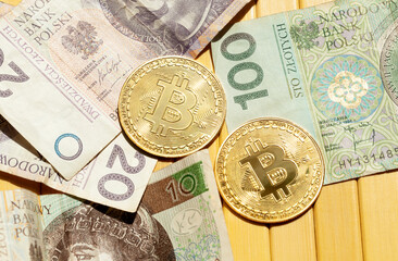 Bitcoin golden coins and Polish zloty bills, money closeup. Cash and cryptocurrency laying on the table, top view, from above. Crypto currency day trading, exchange, earning money abstract concept