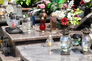 Candles, many votive lights and flowers, decoration on a grave closeup. Lights at the cemetary...