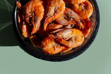 Shrimps in a transparent bowl on an olive background.  King Prawns Olive Gray Background. Plate King Prawns Top View