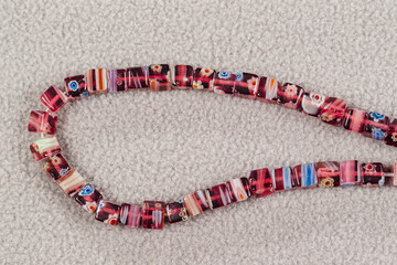 a stand of square multicolored beads for the creation of jewelry