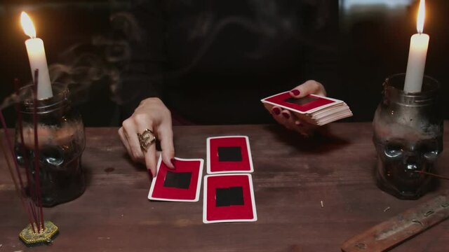 Close up of woman fortune teller placing cards in order as mystic rite.