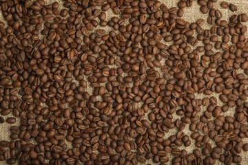 roasted coffee in beans, sprinkled on burlap