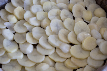 Raw potato. Sliced potatoes on a cutting Board. Raw potatoes cut in circles and a knife on a cutting Board