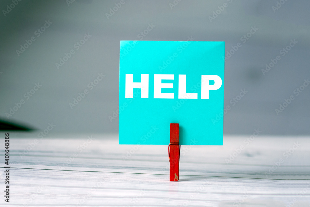 Poster reminder sticky note with clothes pin on table. sticky note with word help. support and assistance c