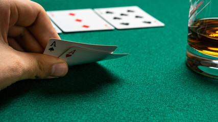 Poker player sees his two cards and drinks whiskey.