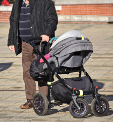 Man with a baby carriage on the street