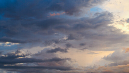 Magnifiques teintes orangées sous des nuages de moyenne altitude, pendant le coucher du soleil.  Le temps est instable