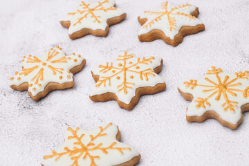 Homemade Christmas gingerbread cookies on white background. Cookies of snowflake shape in sugar glaze. Macro shot.