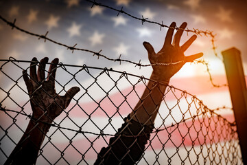 Refugee men and fence  ,United States of America flag in background, immigration concept