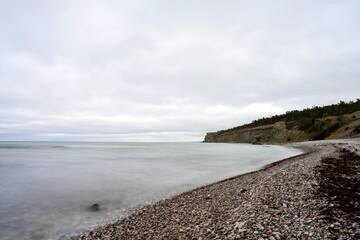 Stone beach with cliff background