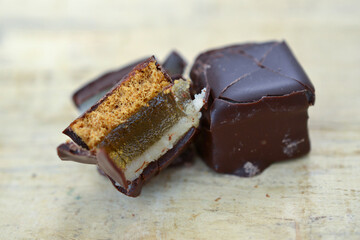 filled chocolate marzipan cubes close up ,sweet food on wood background