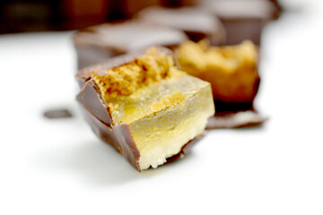 filled chocolate marzipan cubes close up ,sweet food on white