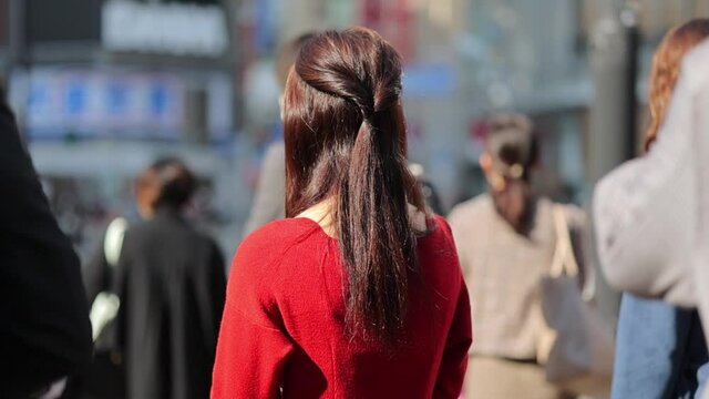 渋谷スクランブル交差点に立つ女性の後ろ姿のスローモーション