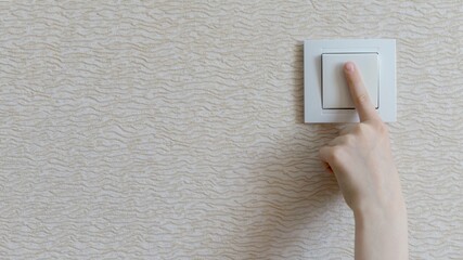 Energy saving. The child turns off the light in the room.