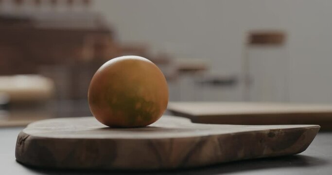 Slow motion man put lulo fruit on olive wood board with copy space