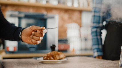 Close Up of a Masculine Hand Holding a Credit Card with an NFC Payment Technology Used for Paying for Croissant in a Cafe. Customer Uses Debit Card to Pay for Latte Through a Bank Terminal.