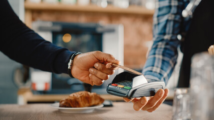 Close Up of a Masculine Hand Holding a Credit Card with an NFC Payment Technology Used for Paying...