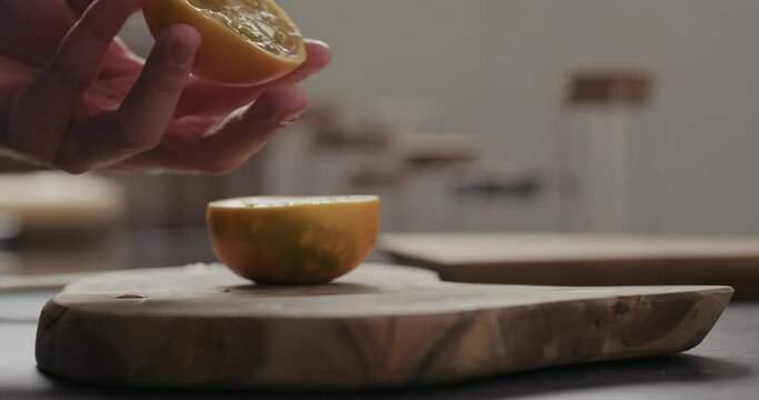 Slow motion man scoop lulo fruit with a spoon on olive wood board with copy space