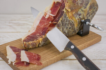 Serrano ham leg shoulder on its wooden base ready to be cut