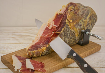 Serrano ham leg shoulder on its wooden base ready to be cut