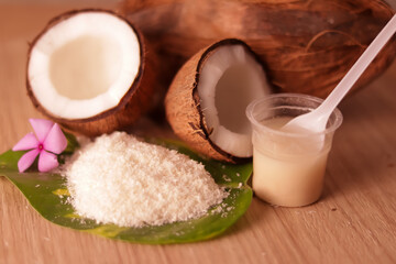 Cracked coconut and grated coconut flakes on wooden,coconut and coconut milk in glass on wooden table, fresh and healthy coconut milk and half coconut fruit