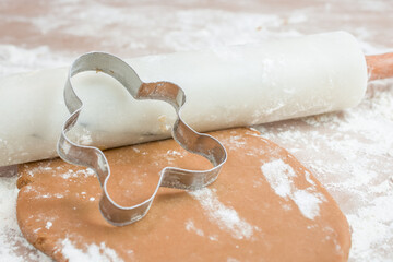 The process of baking cookies at home, closeup on cookie cutter on dough and rolling pin