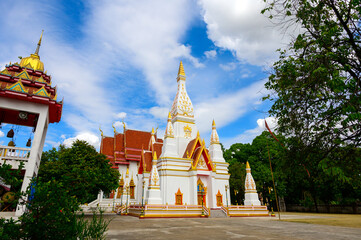 Naklejka premium Beautiful White buddhist pagoda on blue sky with white clouds,Wat Nong Khrok,Sisaket province,Thailand.