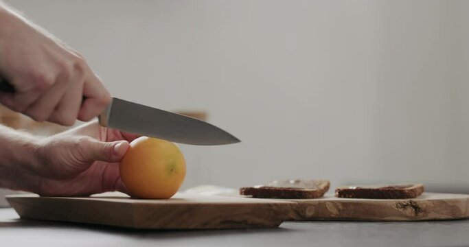 Slow motion man cut lulo fruit on olive wood board with copy space